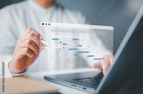 Office manager working with Gantt chart schedule for plan tasks and progress. Corporate strategy for construction, operations, sales, and marketing. Project management planning software concept.
