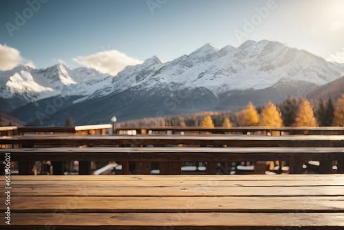 Empty wooden table top with mountain ski hotel and mountains with snow on top of mountains in background with bokeh autumn sunlight. Generative Ai.