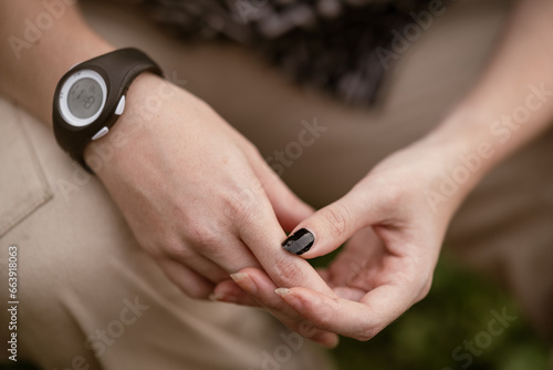 woman s hands with black painted nails and a watch