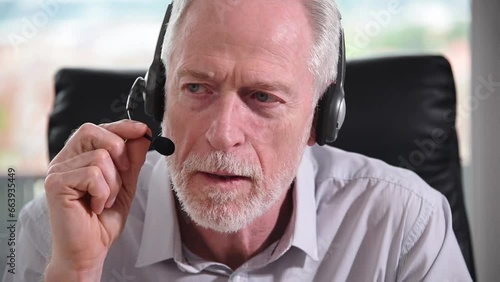Senior businessman with headset having online conference
