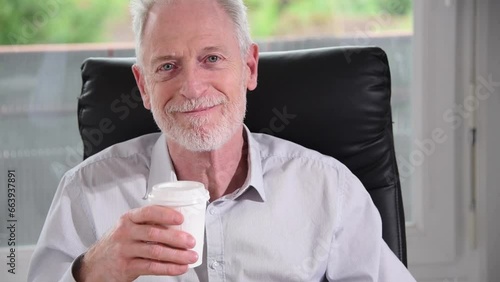 Smiling businessman having coffee break at office