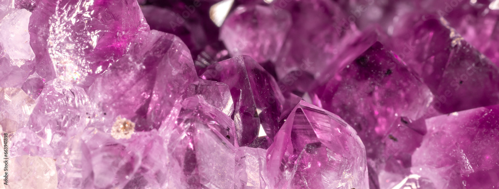 Amethyst purple crystals. Gems. Mineral crystals in the natural environment. Texture of precious and semiprecious stones. Seamless background with copy space colored shiny surface of precious stones. Amethyst purple crystals. Gems. Mineral crystals in the natural environment. Texture of precious and semiprecious stones. Seamless background with copy space colored shiny surface of precious stones.