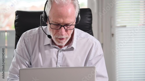 Senior businessman with headset having online conference