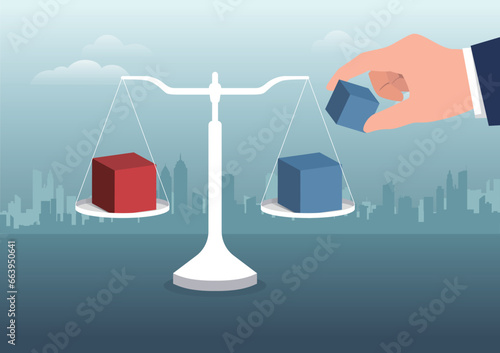 A hand put a cube to add weight at one side.Market intervention, adjustment concepts.