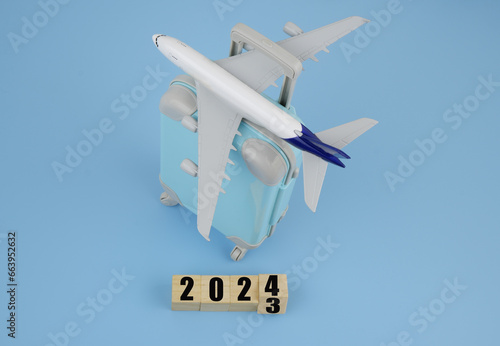 Transport and tickets in year 2024. Airplane with bag and numbers 2023 and 2024.