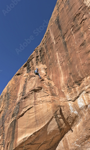 Canvas Print Rock Climber Rappelling Down Textured Red Sandstone Wall in Utah Canyon, USA
