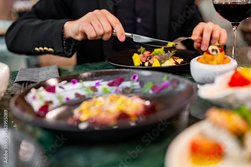 man hands eats meat with red wine in a restaurant