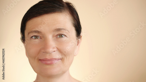 Middle aged mature happy Caucasian woman 50s with wet hair, looking at camera, smiling, isolated background, close up portrait. Advertisement for anti-aging whitening, skin care. Copy space.