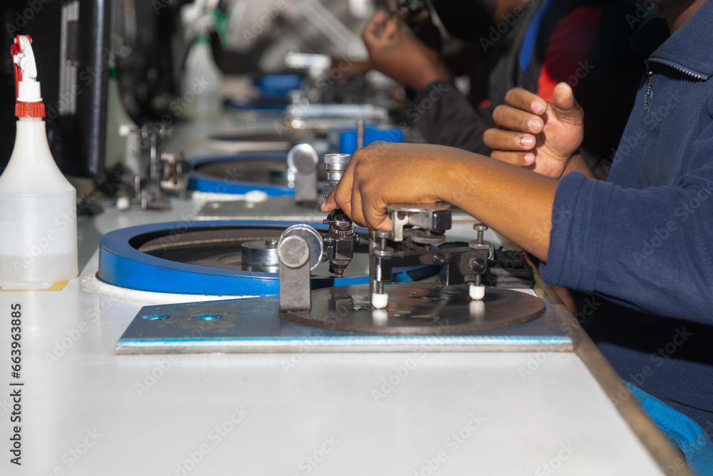 woman african worker polishing a diamond in the factory at the spinning wheel