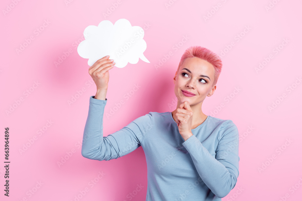 Portrait of thoughtful woman with dyed hairdo wear stylish clothes look at dialog cloud hand on chin isolated on pink color background Portrait of thoughtful woman with dyed hairdo wear stylish clothes look at dialog cloud hand on chin isolated on pink color background