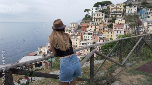 Obraz na płótnie Europe, Italy, Liguria, Cinque Terre Riomaggiore - girl lady tourist with hat visiting The Cinque Terre tourist attraction for tourists from all over the world Unesco Heritage - tourist destination w salonie