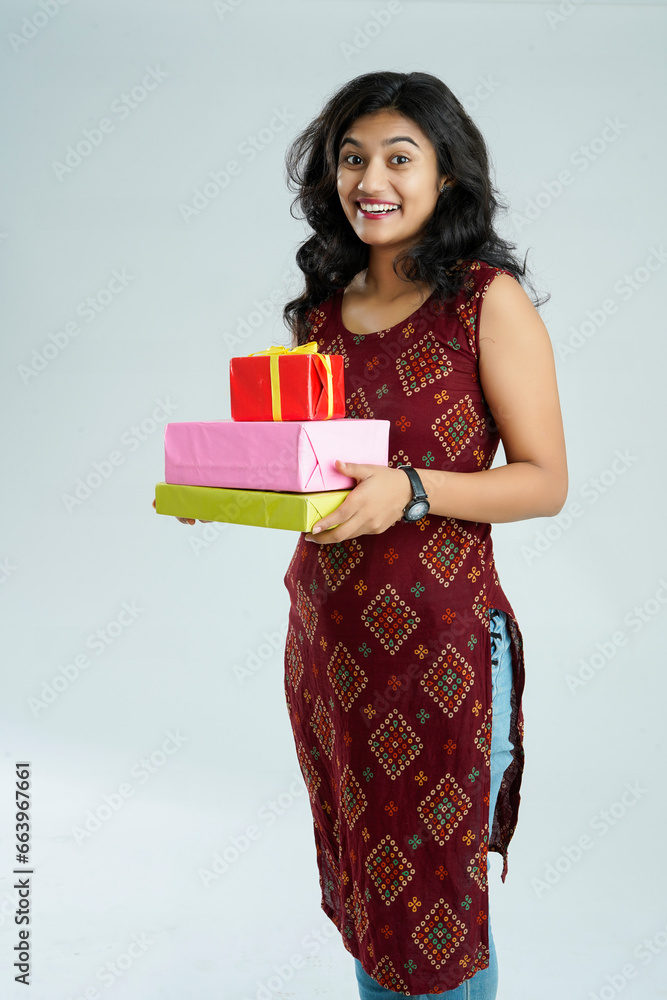 Happy beautiful indian woman wearing traditional outfit holding gift boxes Happy beautiful indian woman wearing traditional outfit holding gift boxes