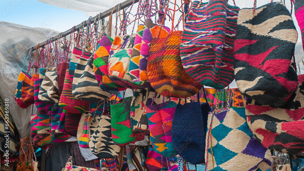 Shigras hanging for sale in the Plaza de los Ponchos in the city of Otavalo. Shigra is a hand-woven indigenous bag.