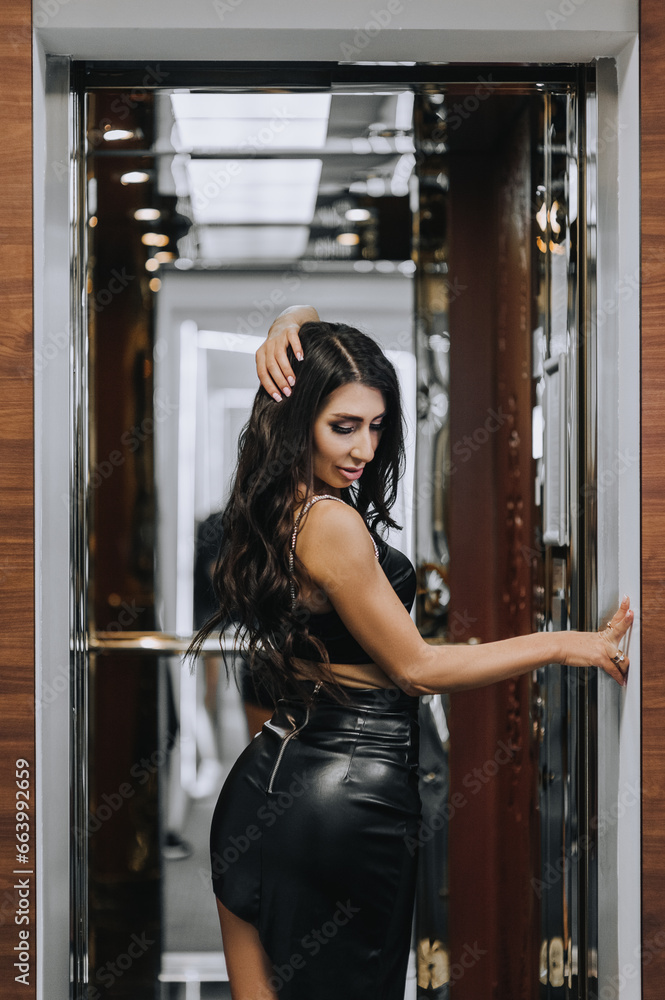 Photo, close-up portrait of a beautiful sexy young girl, brunette woman with curly hair, Armenian woman in black lingerie, leather dress in a retro hotel elevator. Photo, close-up portrait of a beautiful sexy young girl, brunette woman with curly hair, Armenian woman in black lingerie, leather dress in a retro hotel elevator.