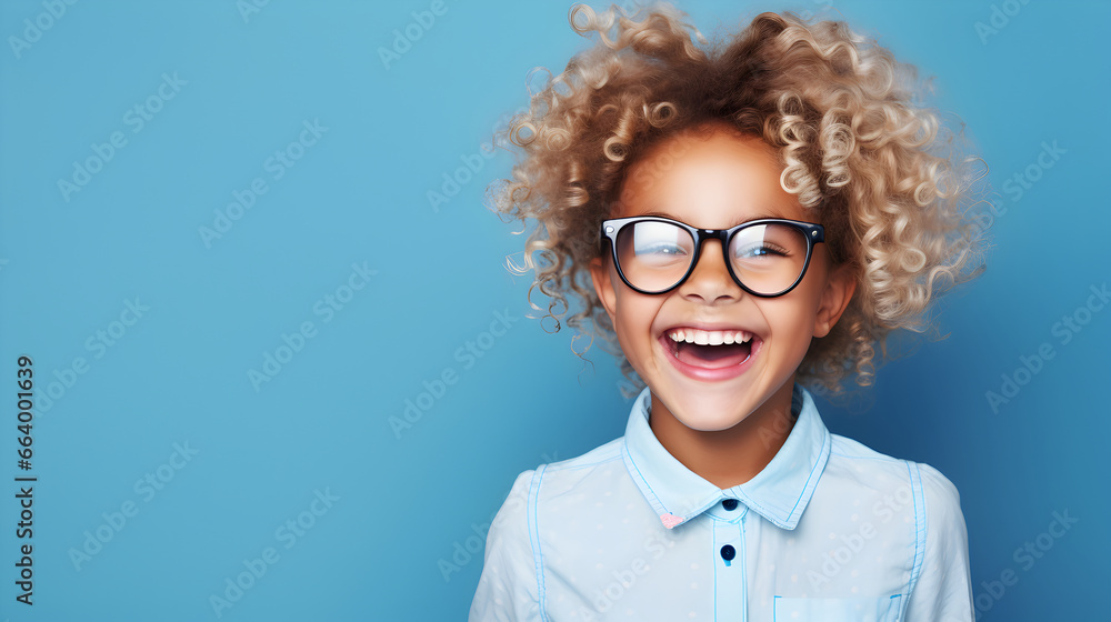 Happy girl child wearing big eyeglasses Isolated on solid blue background Happy girl child wearing big eyeglasses Isolated on solid blue background