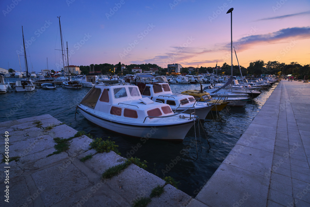 Port on the Adriatic Sea in the Croatian town of Krk with moored boats at sunset. Port on the Adriatic Sea in the Croatian town of Krk with moored boats at sunset.