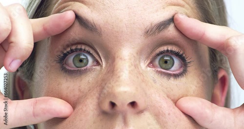 Hands, open eyelid and tired face for woman, check vision or health with retina exam for wellness. Person, eyes and stretching for test, fatigue and burnout with fingers, skin and pupil in closeup photo