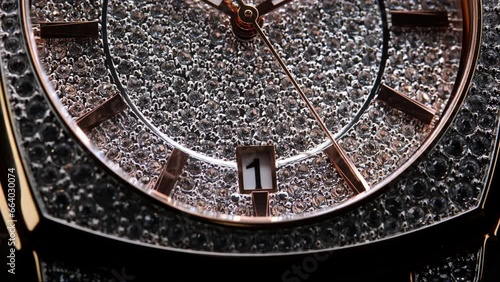 Extreme closeup of yellow second arrow passing by on diamond clock face. Lengthwise view of luxury swiss watch. Closeup real time shot. Running second arrow. expensive watch with diamonds