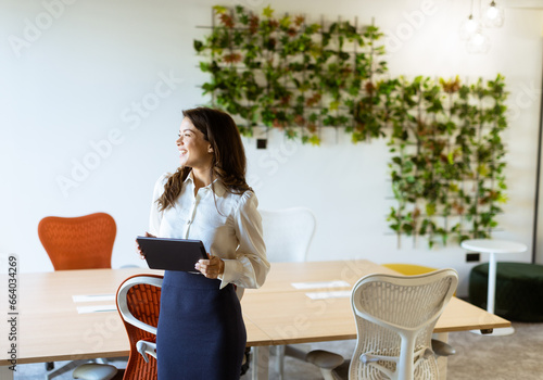 Young woman with digital tablet standing in the modern office