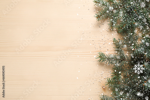 Obraz na plátně Beautiful Christmas tree branches and snow on wooden background with space for t