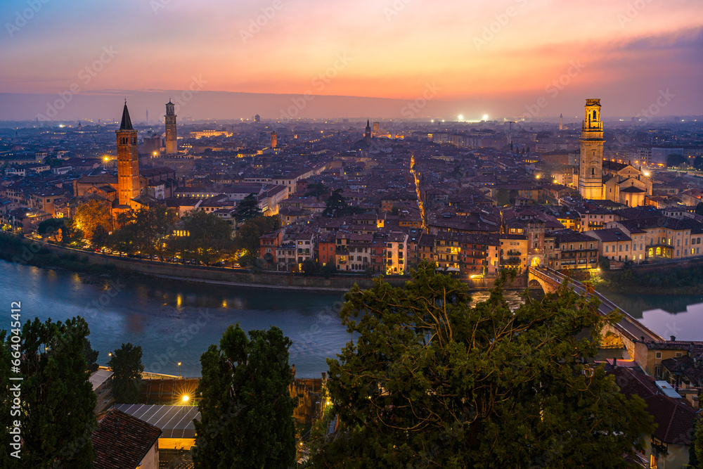 Verona, Veneto, Italy: Twilight skyline by river Adige with Saint Anastasia church,  Lamberti tower and hte cathedral of Verona