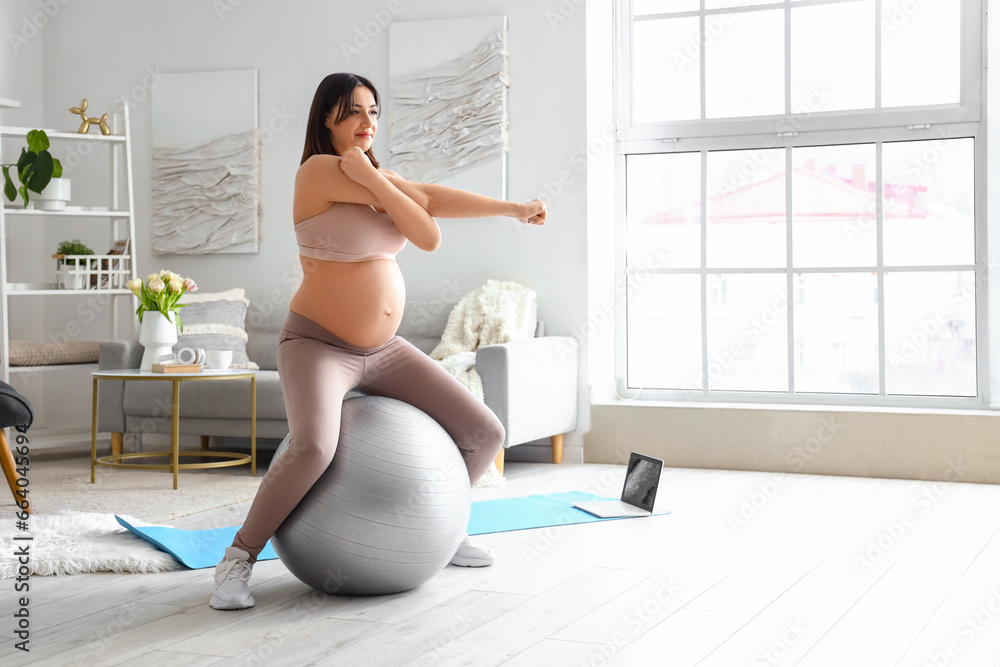 Sporty young pregnant woman training with fitball at home Sporty young pregnant woman training with fitball at home