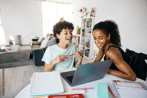 Canvastavla Cheerful woman helping her smiling daughter doing homework