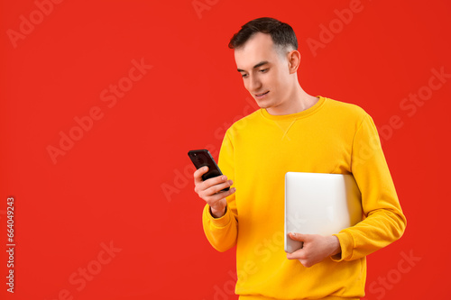 Young man with laptop and m...