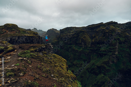 фотографія A man on a cliff is looking down into a chasm in the mountains of Iceland
