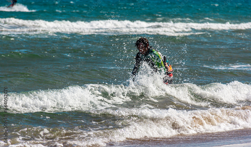 Sportsman practicing kite surf sport at the beach on a windy day Sportsman practicing kite surf sport at the beach on a windy day