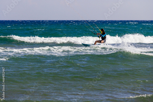 Man practicing kitesurfing on the waves