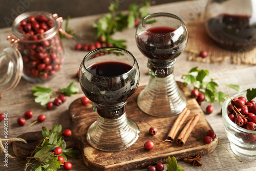 Two vintage glass cups of medicinal wine made of fresh hawthorn berries