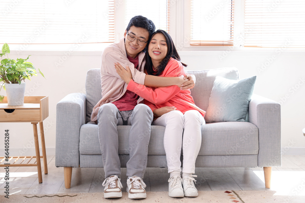 Young Asian friends hugging on sofa at home Young Asian friends hugging on sofa at home