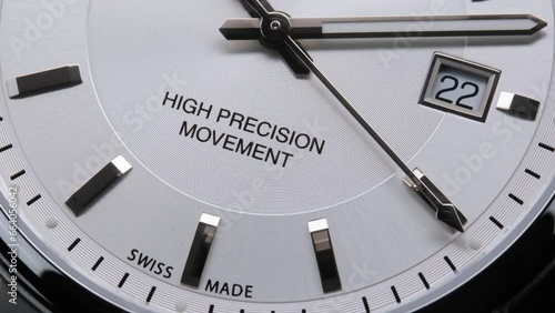 Second arrow running on the black clockface of luxury swiss watch with chronograph. Light flash on the turning clockface. Closeup real time shot. Running second arrow