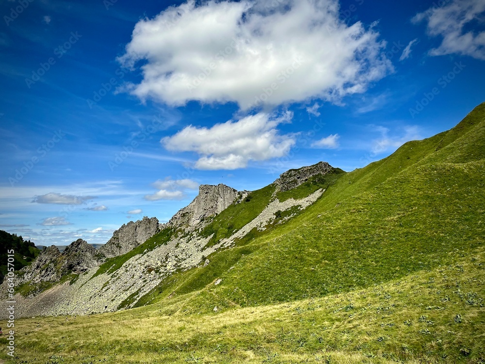 mountain landscape on a summer day with rocky peaks and alpine meadows
