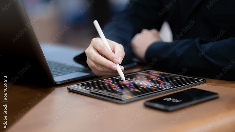 Businessman checks and manages his weekly schedule on a tablet. - obrazy, fototapety, plakaty 