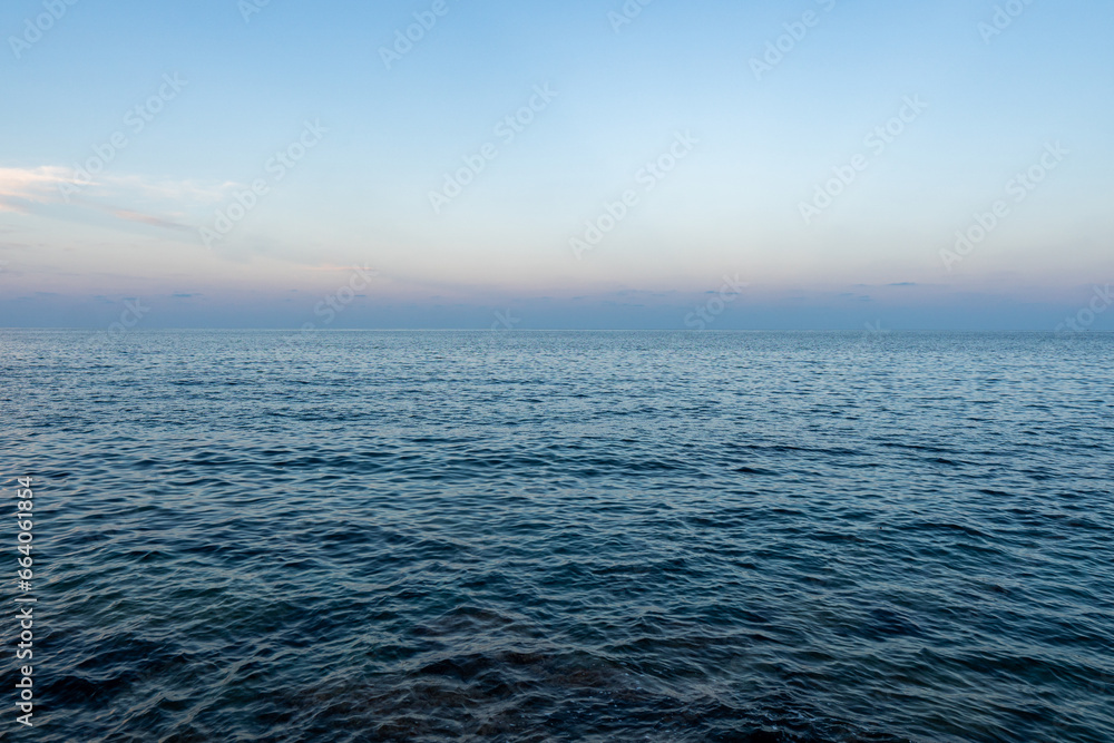 The blue mediterranean sea and a colorful horizon at Cala Ratjada on Majorca Island, Spain - obrazy, fototapety, plakaty 
