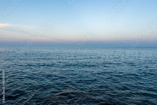 The blue mediterranean sea and a colorful horizon at Cala Ratjada on Majorca Island, Spain photo
