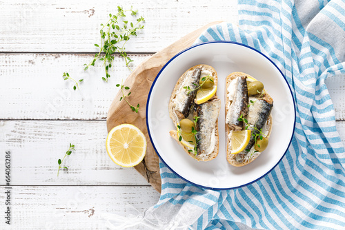 Sardines sandwiches on a white wooden background. Mediterranean food. Top view photo