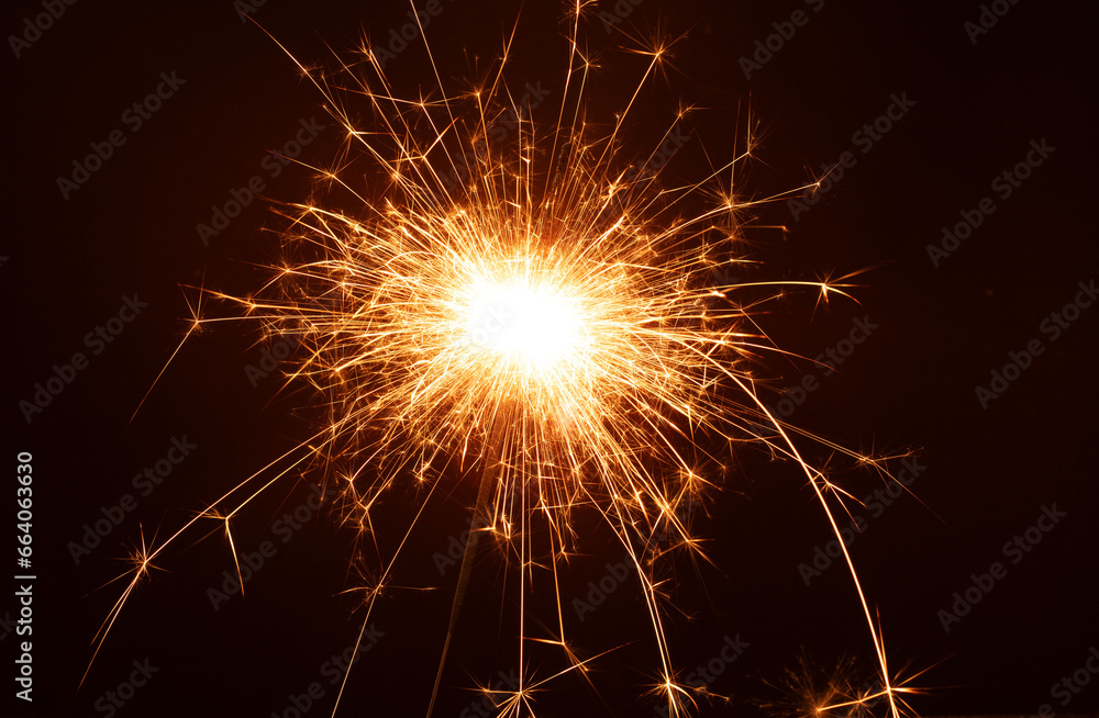 photo a close-up captures the fiery magic of a sparkler at a New Year's party. In the dark, it burns with brilliance, creating a close, celebratory atmosphere and leaving ample copy space