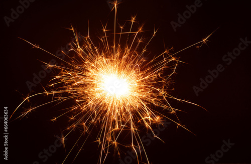 photo amidst the black background  a glowing sparkler ignites the atmosphere  creating a celebration sparks leaves a trail offering a striking image with copy space.