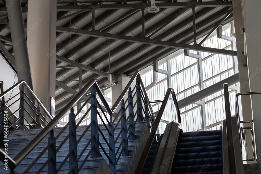Naklejka premium Abstract industrial interior with stairway and an escalator