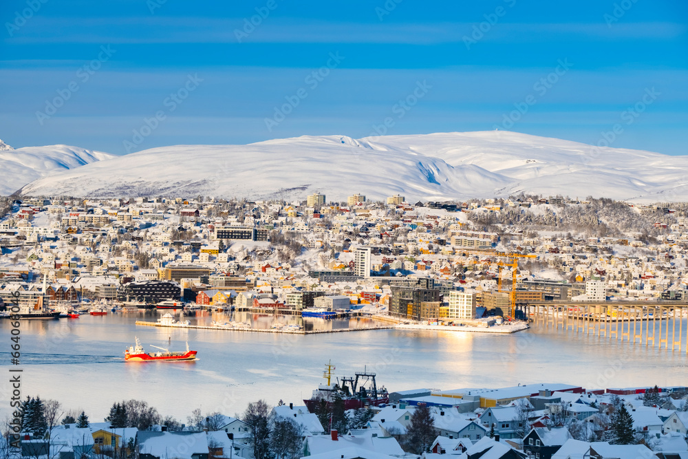 Snowy roofs, embankment near the port and fishing ships, Sunny winter day.
