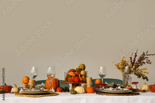 Festive table setting for Thanksgiving Day with pumpkins, dried flowers and pine cones