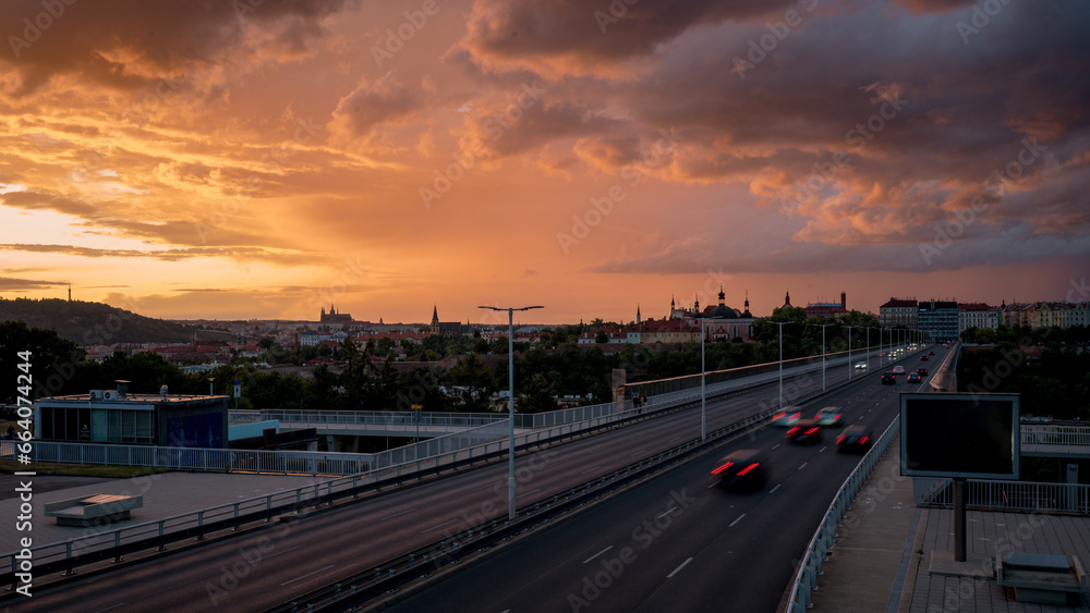 View of Prague from the Nuselský Bridge at sunset with the Prague skyline and the castle in the background. Storm clouds.