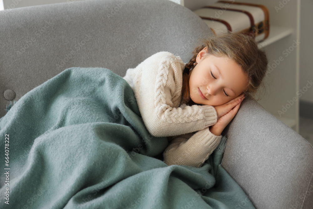 Cute little girl with warm plaid lying in armchair at home Cute little girl with warm plaid lying in armchair at home