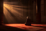 Muslim man praying in the mosque with rays of light coming through the window