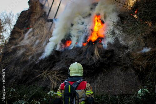 Firefighter by a housefire photo