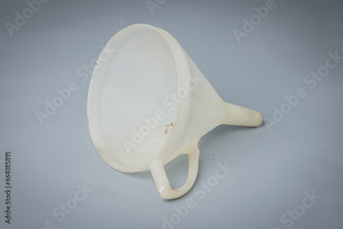 White funnel used for liquids isolated on gray color. Practical funnel for help when pouring liquids or similar material.