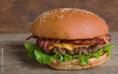 Tasty hamburger with cutlet grilled on a wooden surface with french fries 